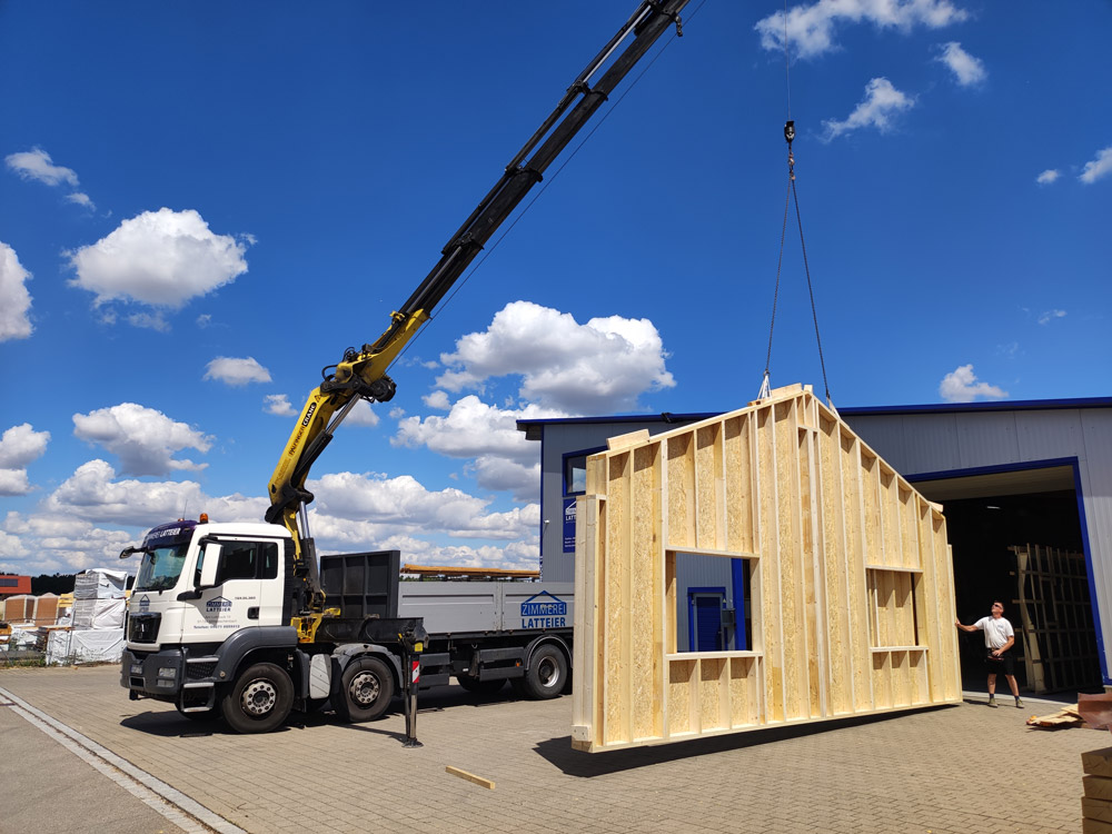 Holzwände einer Industriehalle werden mit dem Autokran angeliefert